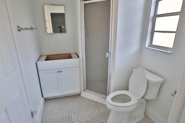 bathroom with tile patterned floors, toilet, vanity, and walk in shower