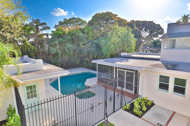 view of swimming pool featuring a patio and a sunroom