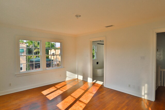 spare room with hardwood / wood-style floors and ornamental molding