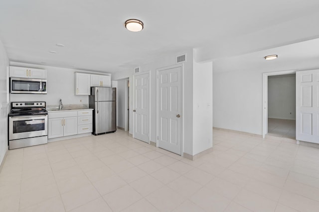 kitchen with sink, appliances with stainless steel finishes, and white cabinets