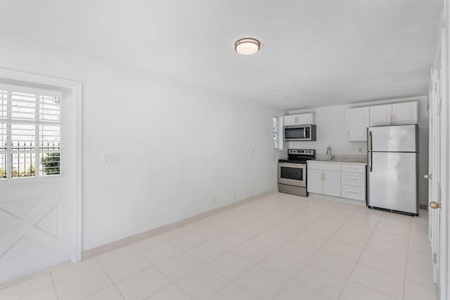 kitchen with sink, stainless steel appliances, white cabinetry, and a wealth of natural light