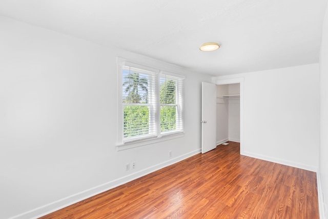 unfurnished bedroom featuring a closet and hardwood / wood-style flooring