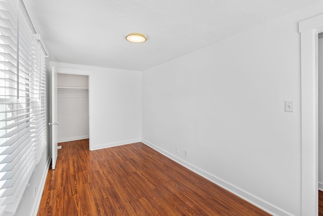 unfurnished bedroom featuring a closet and dark hardwood / wood-style floors