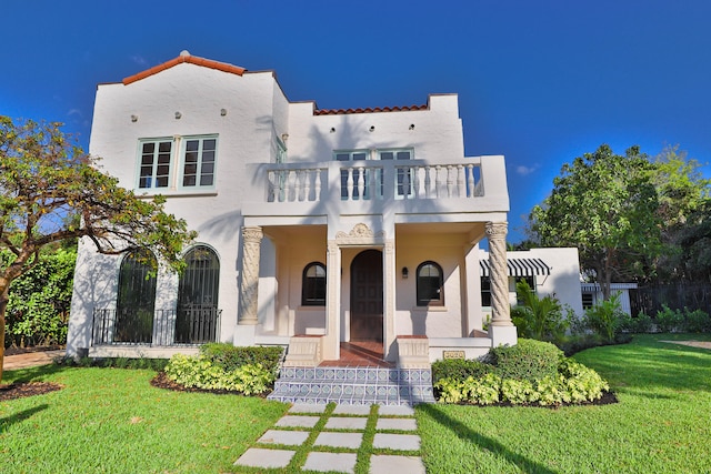 mediterranean / spanish home featuring a front yard, a balcony, and a porch