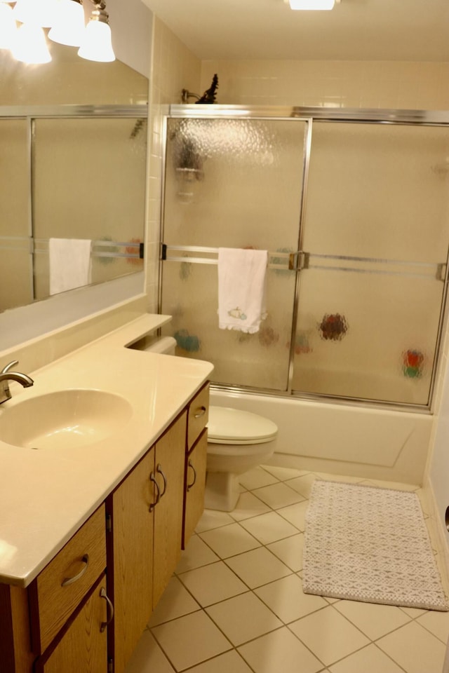 full bathroom with toilet, vanity, bath / shower combo with glass door, and tile patterned flooring