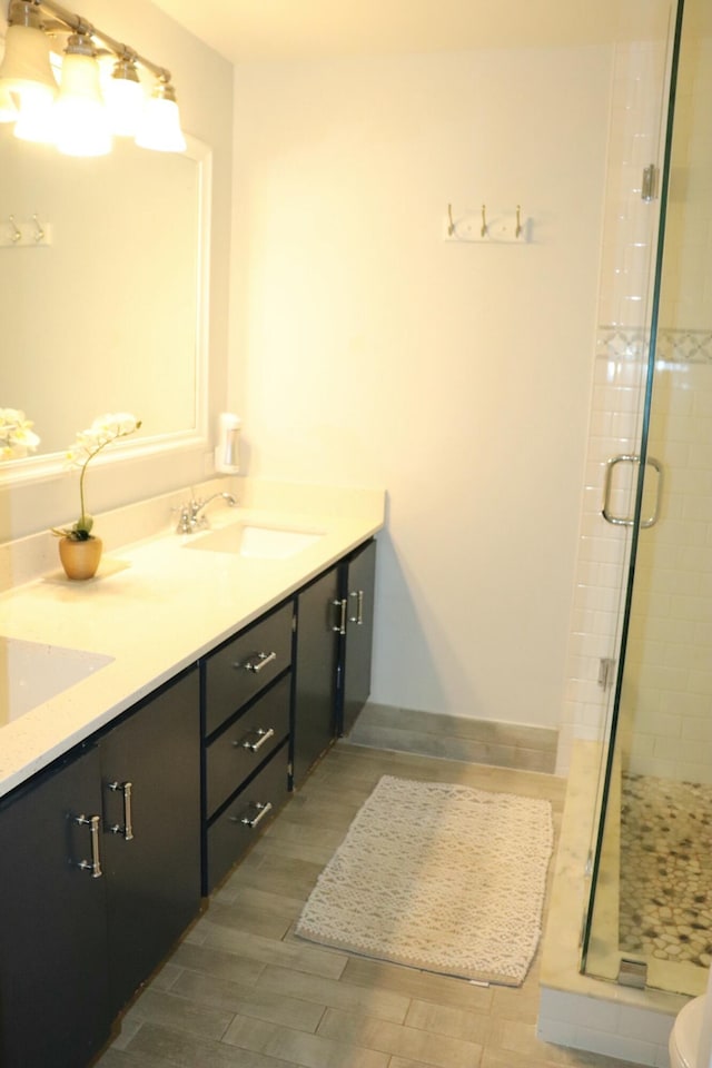 bathroom with vanity, toilet, a shower with shower door, and hardwood / wood-style floors