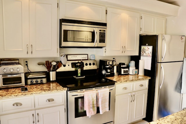 kitchen featuring stainless steel appliances, white cabinetry, and light stone countertops