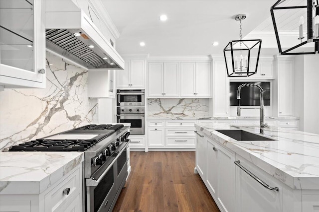 kitchen with white cabinets, wall chimney exhaust hood, sink, and stainless steel appliances