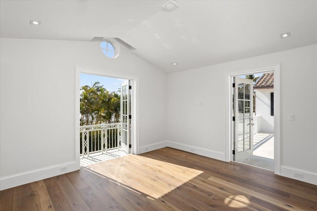 spare room featuring vaulted ceiling and dark wood-type flooring