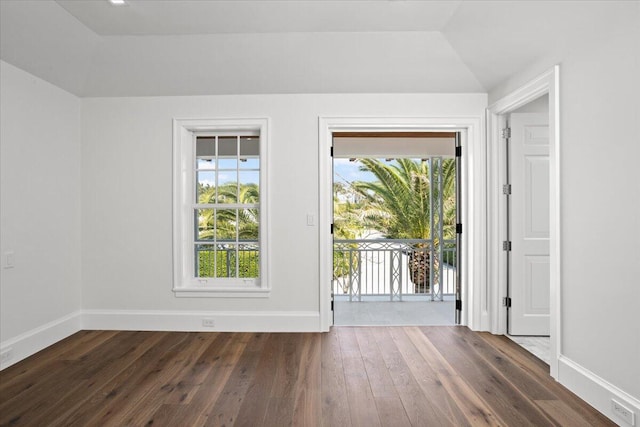 doorway to outside with dark hardwood / wood-style flooring and vaulted ceiling