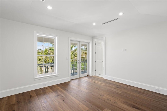 empty room featuring hardwood / wood-style flooring, lofted ceiling, and french doors