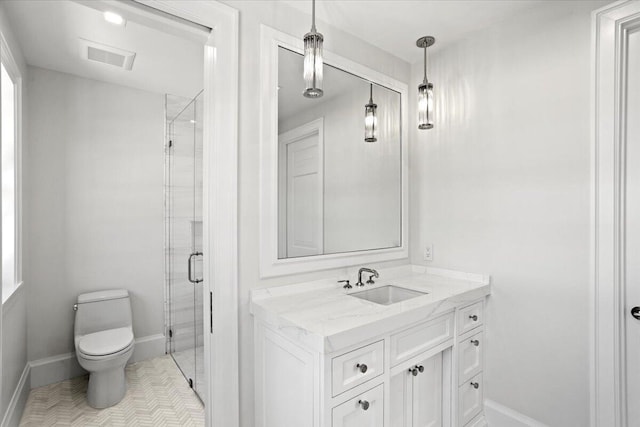 bathroom featuring tile patterned flooring, vanity, toilet, and a shower with door