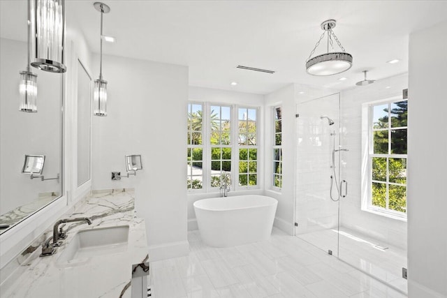 bathroom with vanity and shower with separate bathtub