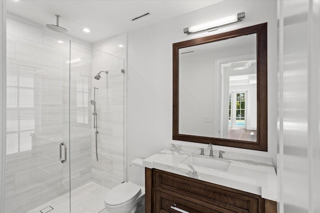 bathroom featuring vanity, toilet, and a shower with door