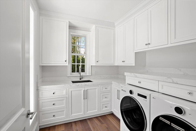 laundry area featuring washing machine and dryer, sink, cabinets, and dark hardwood / wood-style flooring