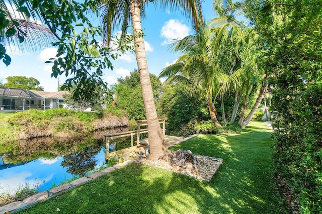 view of yard featuring glass enclosure and a water view