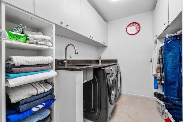 washroom with cabinets, washer and clothes dryer, sink, and light tile patterned floors