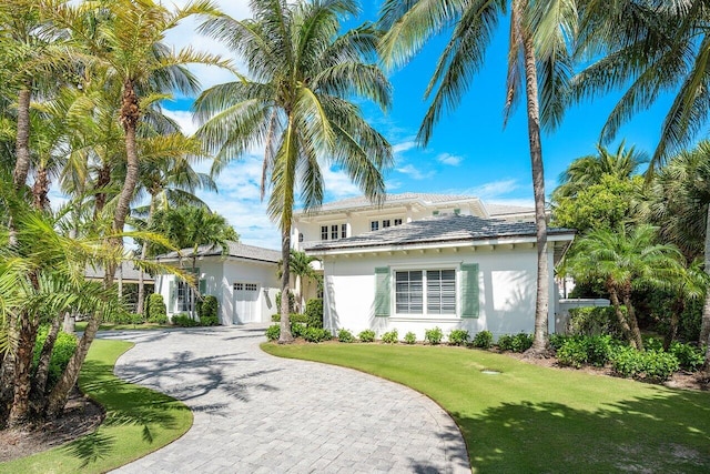 mediterranean / spanish-style home featuring a front yard and a garage