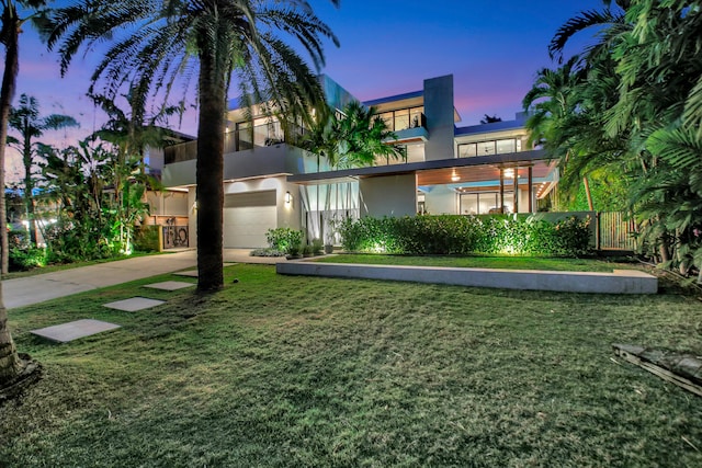 contemporary home featuring a lawn and a garage