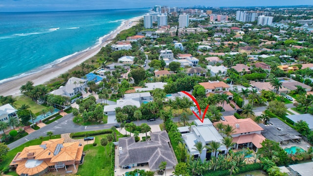 birds eye view of property featuring a water view and a beach view