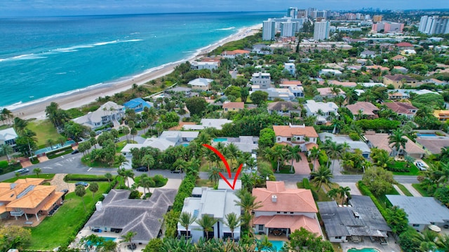 bird's eye view featuring a water view and a beach view