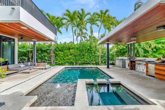 view of pool featuring ceiling fan, outdoor lounge area, a bar, and a patio area