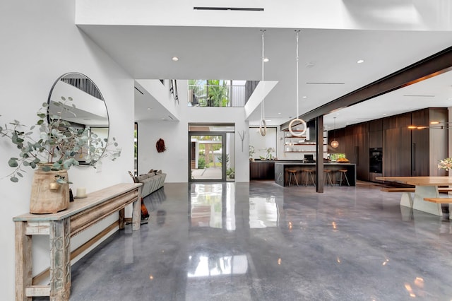 entrance foyer featuring wood walls and a high ceiling