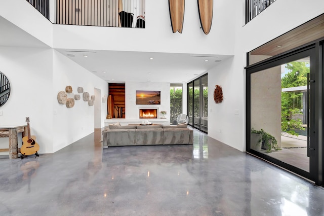 unfurnished living room featuring plenty of natural light and a high ceiling