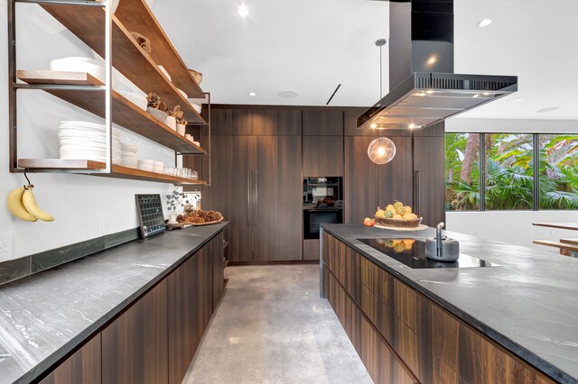 kitchen featuring hanging light fixtures, dark stone countertops, island exhaust hood, and black appliances