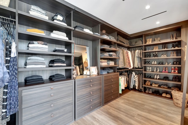 walk in closet with light hardwood / wood-style flooring