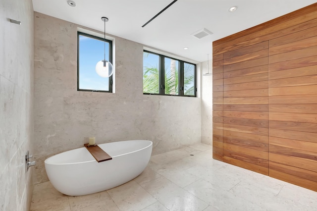 bathroom featuring a washtub and tile flooring