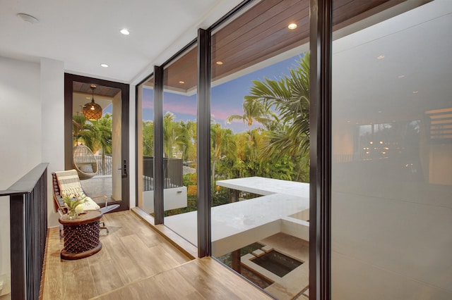 doorway featuring floor to ceiling windows and light wood-type flooring