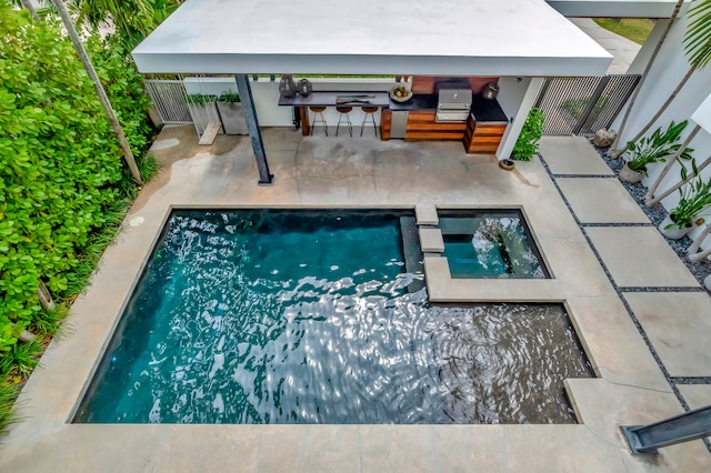 view of pool with a patio area and an in ground hot tub