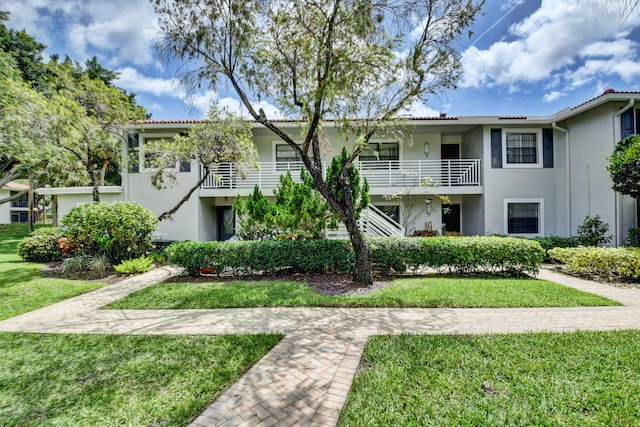 view of front of property with a balcony and a front yard