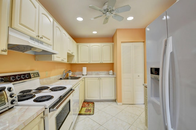 kitchen featuring ceiling fan, sink, light tile patterned floors, and white appliances