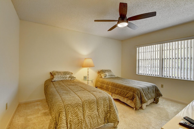 carpeted bedroom with ceiling fan and a textured ceiling