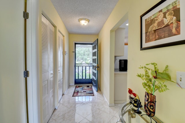 entryway featuring a textured ceiling and light tile patterned floors