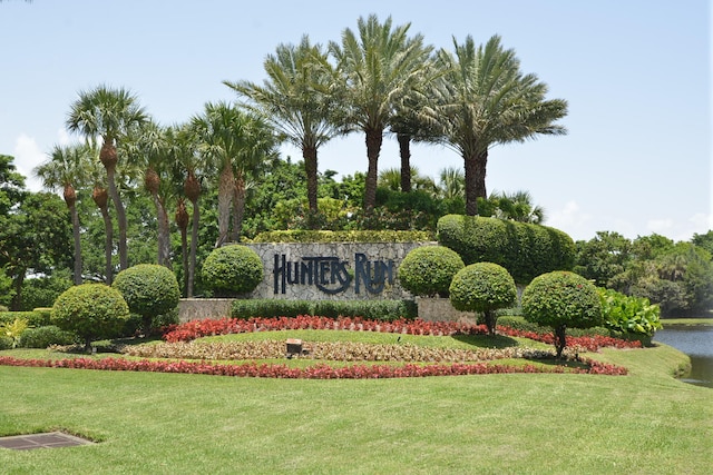 community sign with a water view and a yard