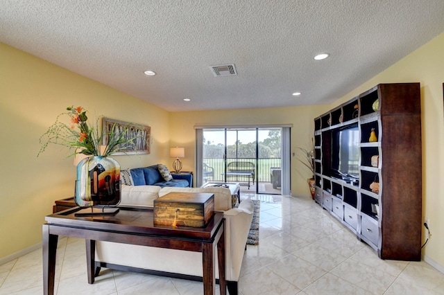 living room featuring a textured ceiling and light tile patterned flooring