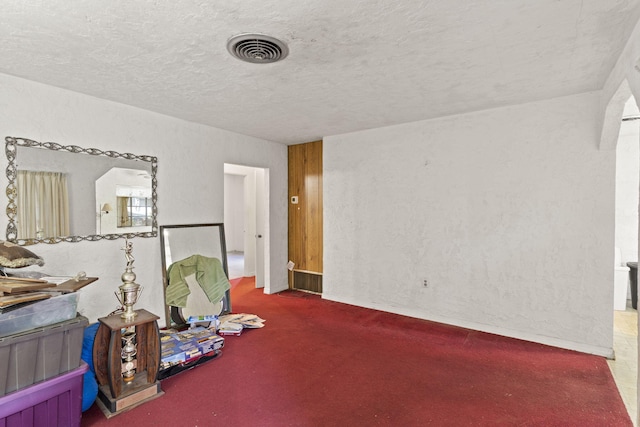 misc room with dark carpet and a textured ceiling