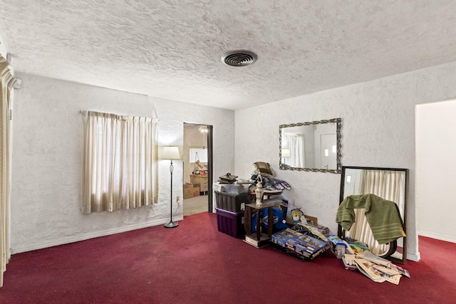 miscellaneous room featuring a textured ceiling and dark colored carpet