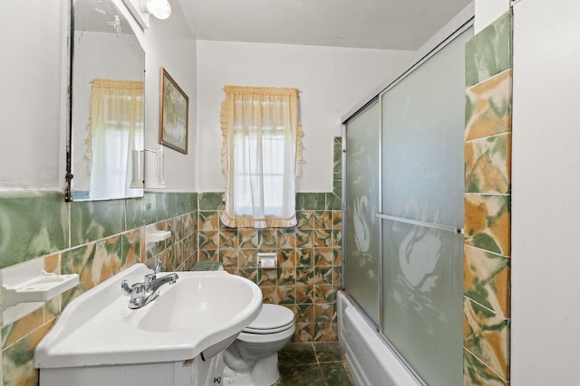 full bathroom featuring tile walls, combined bath / shower with glass door, tile flooring, toilet, and large vanity