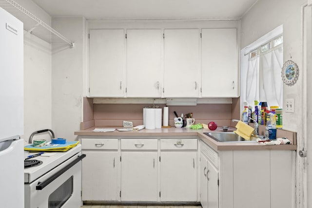 kitchen with white appliances, white cabinetry, and sink