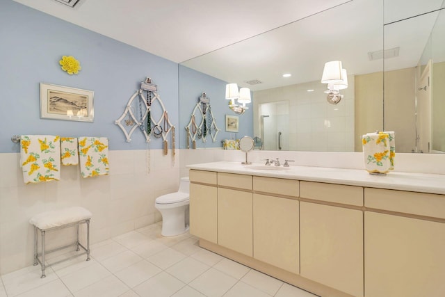 bathroom featuring vanity, tile flooring, toilet, and tile walls