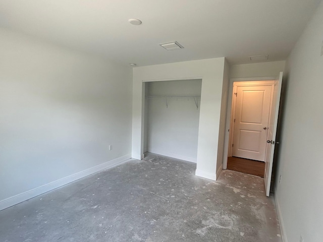 unfurnished bedroom featuring concrete floors and a closet