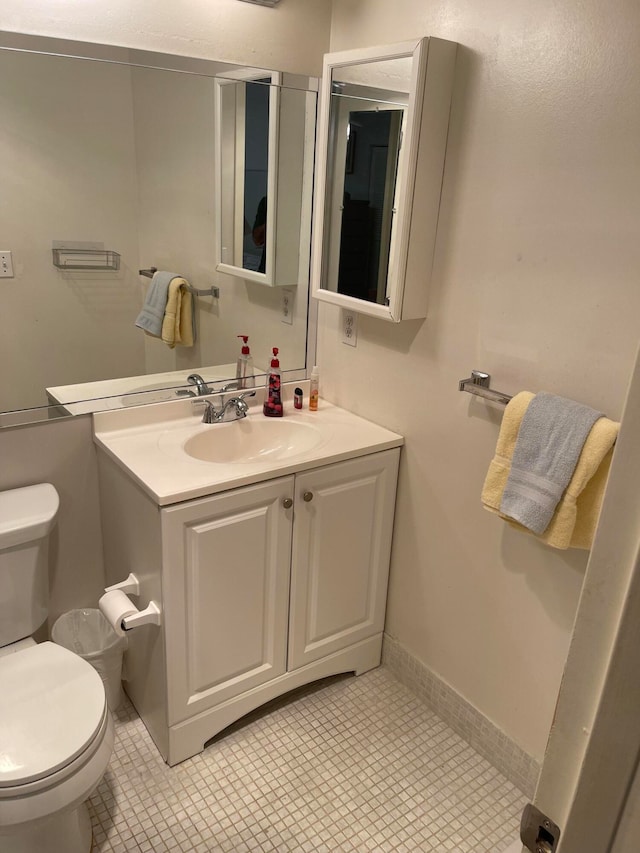 bathroom with vanity, tile floors, and toilet