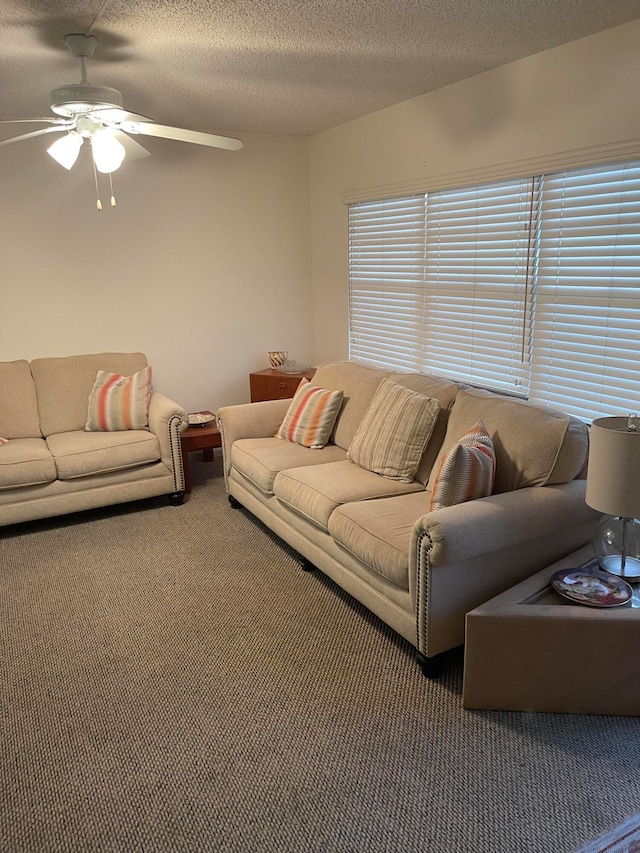 living room with dark carpet, ceiling fan, and a textured ceiling