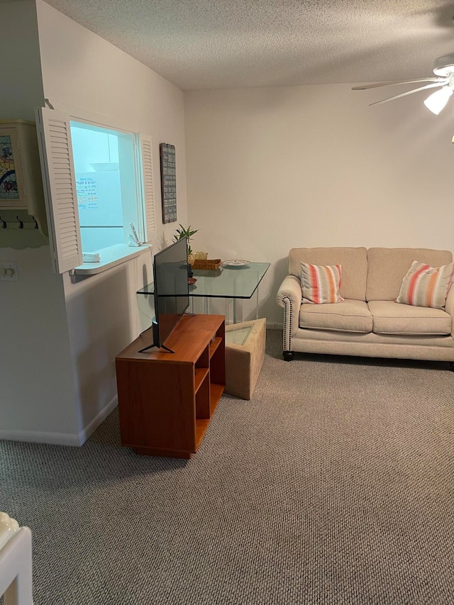 carpeted living room featuring ceiling fan and a textured ceiling