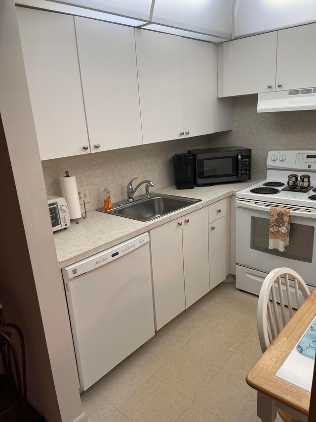 kitchen featuring white appliances, sink, white cabinets, light tile flooring, and tasteful backsplash