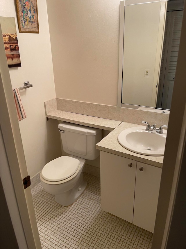 bathroom featuring vanity, tile floors, and toilet